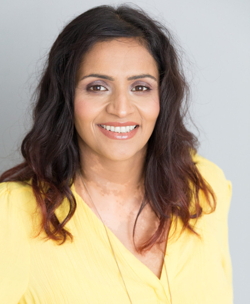 yellow-dress-carola-image-scaled Smiling head and shoulder portrait of an Asian woman with long brown hair rearing a yellow blouse