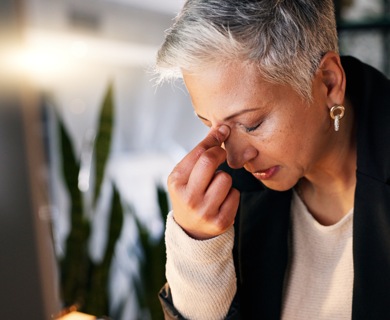 Senior business woman with headache from stress and frust